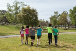 back view of a group of friends walking on the park